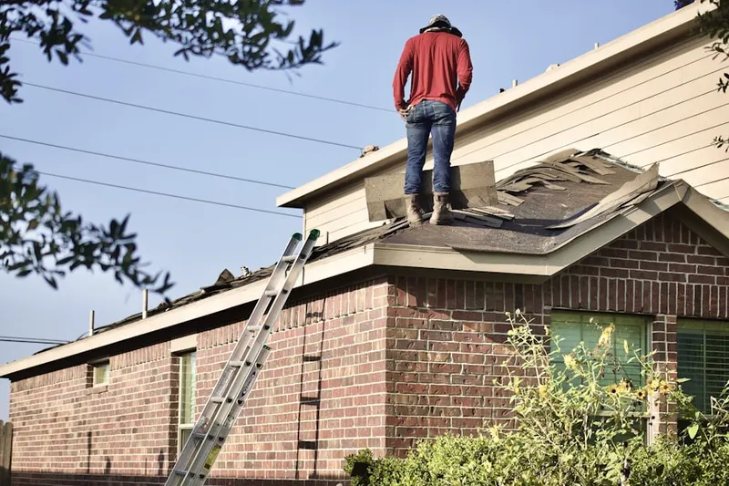 Professional roofer working on a residential roof in Tusculum